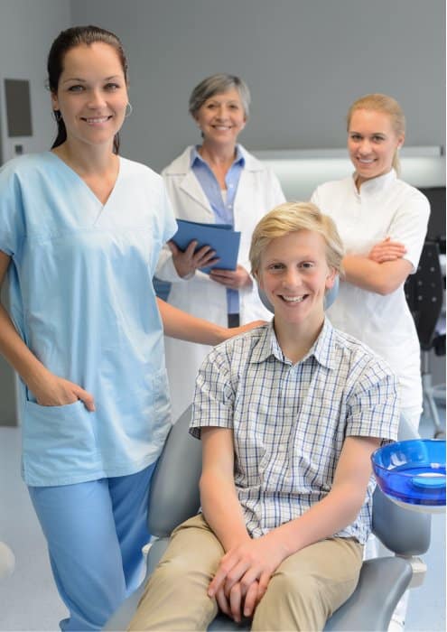 team of dentists with teenager patient boy